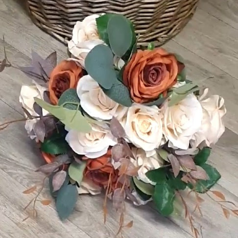 Terracotta Reverie bridal bouquet held up showing terracotta and cream roses with eucalyptus