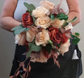 Terracotta Reverie bouquet and matching buttonholes laid on wooden floor