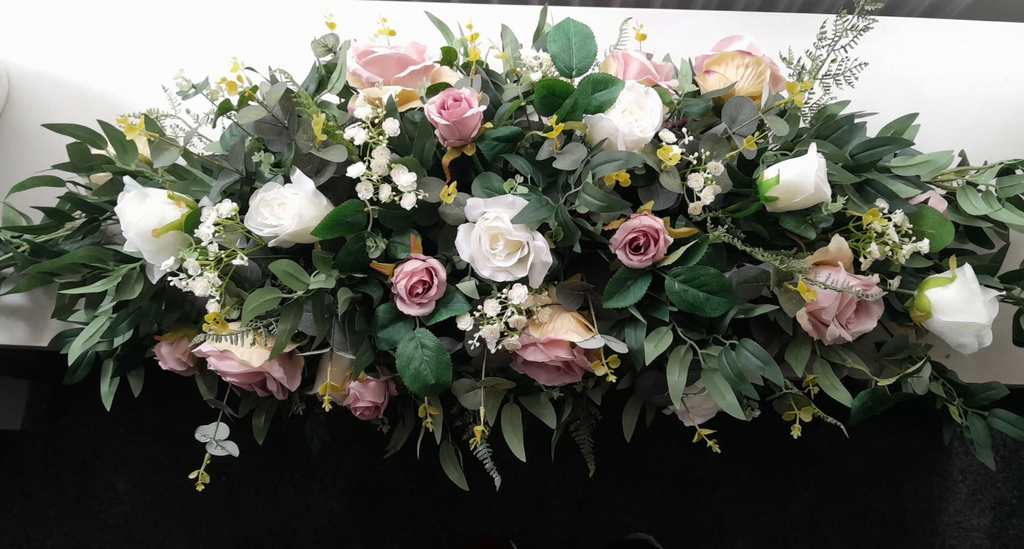 Deluxe top table arrangement with dusky pink and white roses and lush greenery, front view