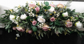 Deluxe top table arrangement with dusky pink and white roses and lush greenery, front view