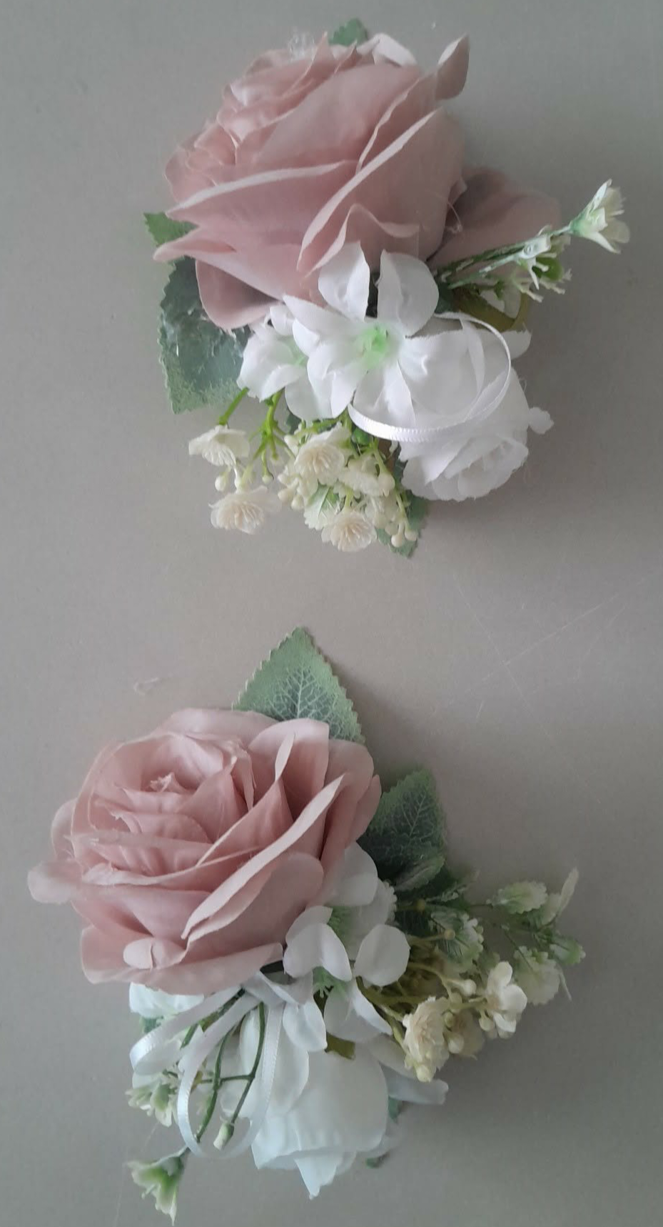 Freya bridal bouquet held in hand featuring dusky pink, sage green and ivory artificial roses with foliage