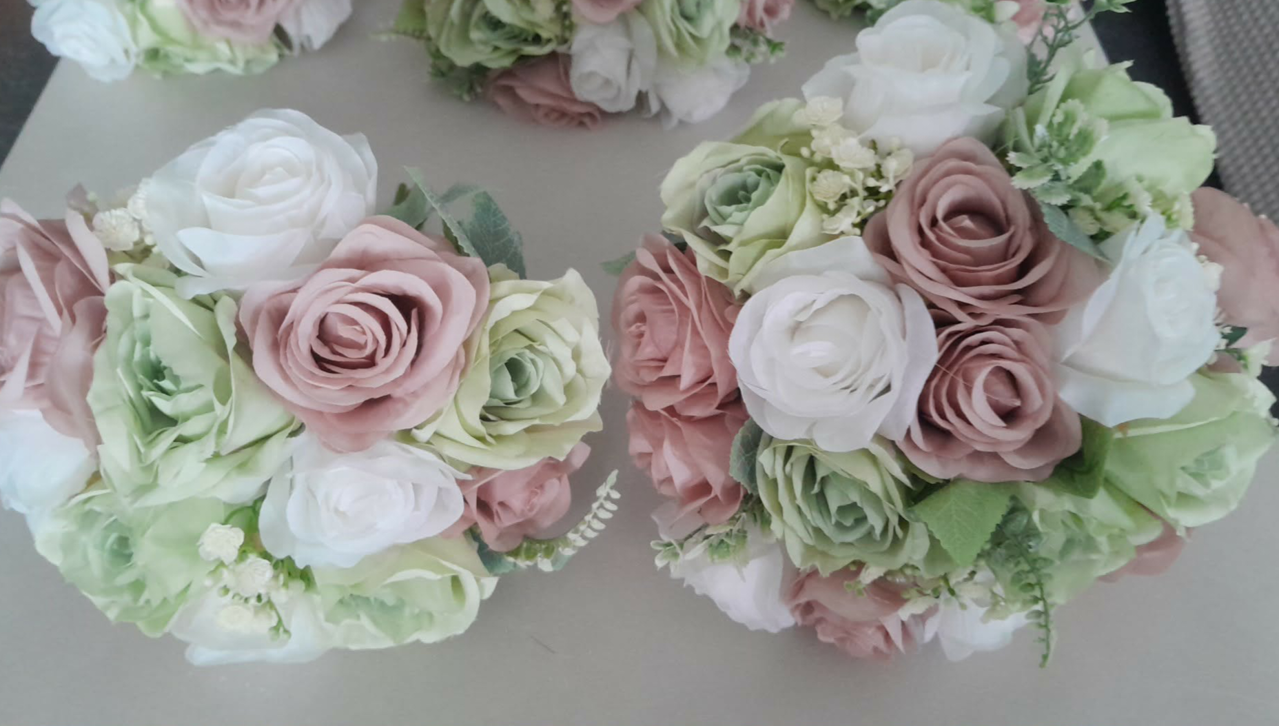 Freya bridesmaid bouquets in dusky pink, sage green and ivory artificial roses viewed from above