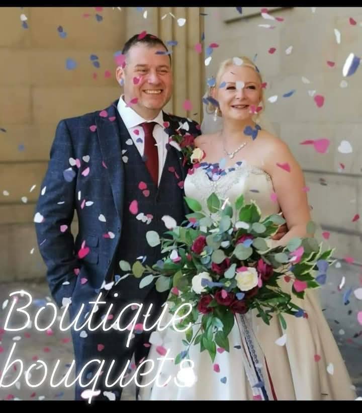 Araminta bridal bouquet outside church - bride holding deep burgundy and ivory cascading bouquet with trailing ribbons