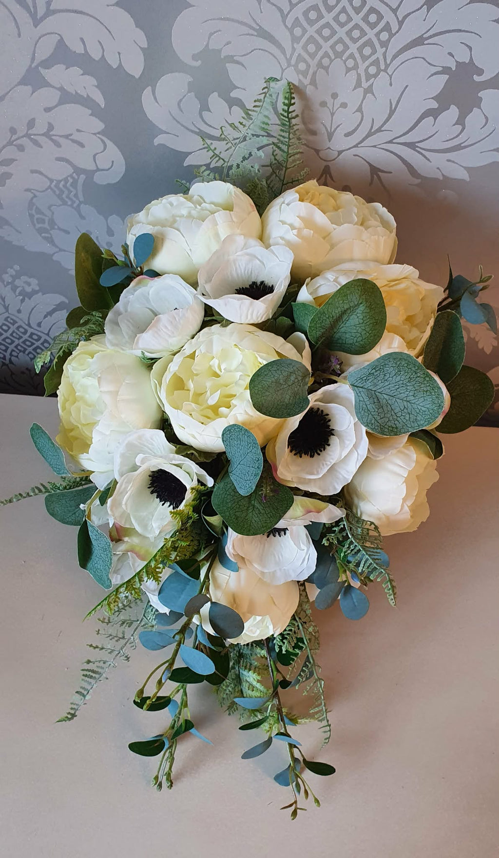 Thessaly cascading bridal bouquet — front view showing dark centred anemones and voluminous ivory peonies