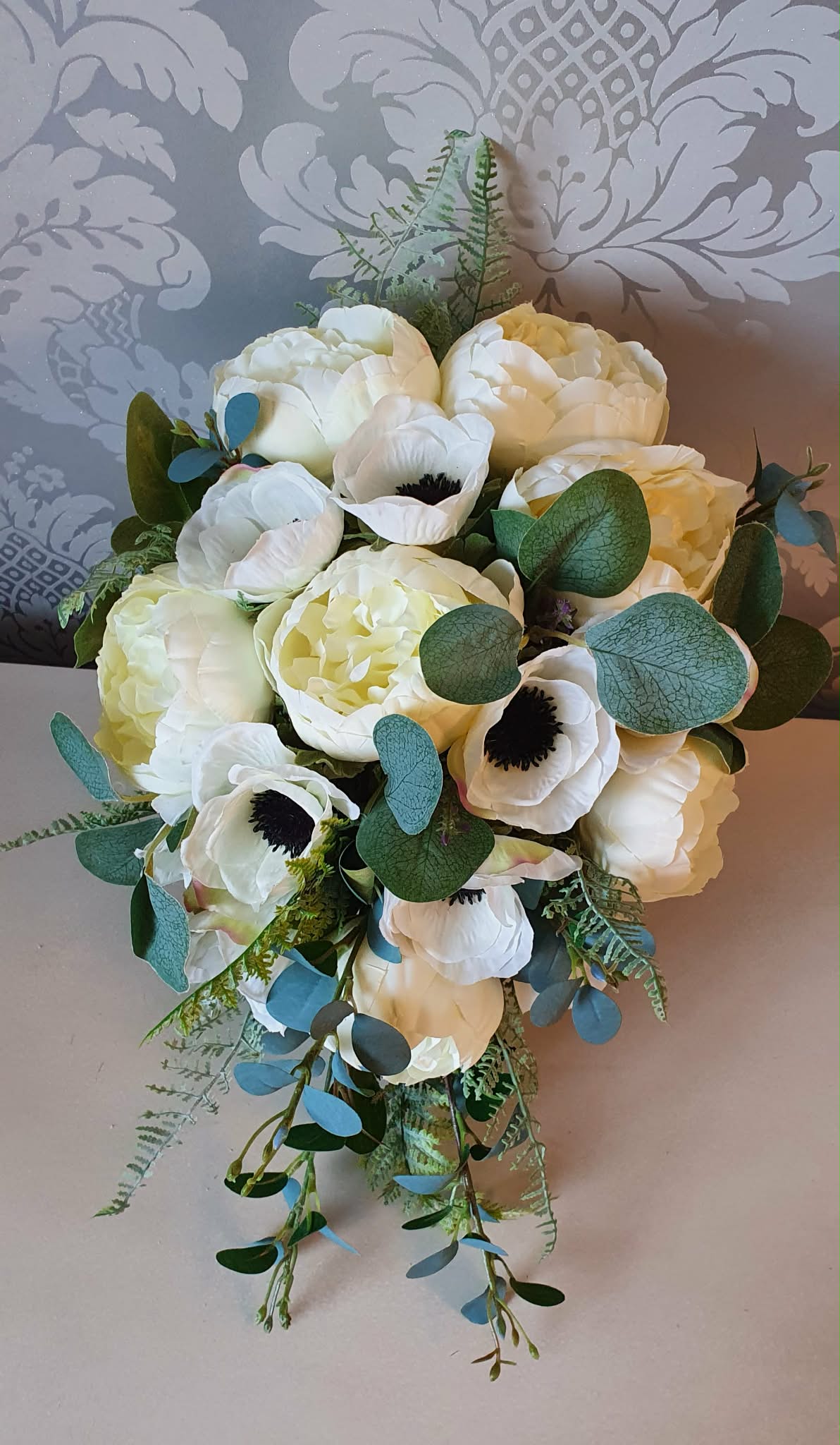 Thessaly cascading bridal bouquet — front view showing dark centred anemones and voluminous ivory peonies