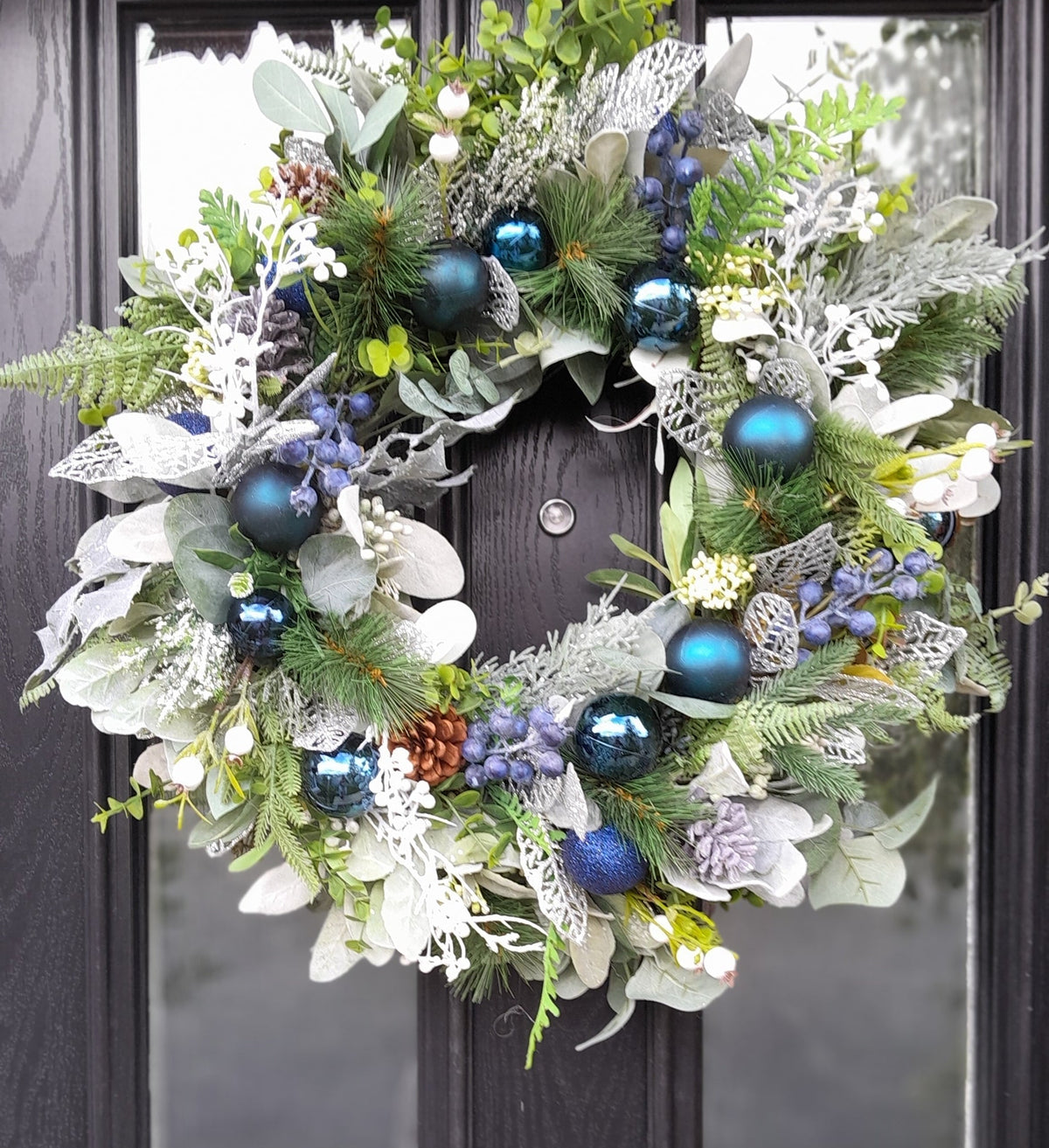 Blue and silver Christmas wreath on a black front door, full view