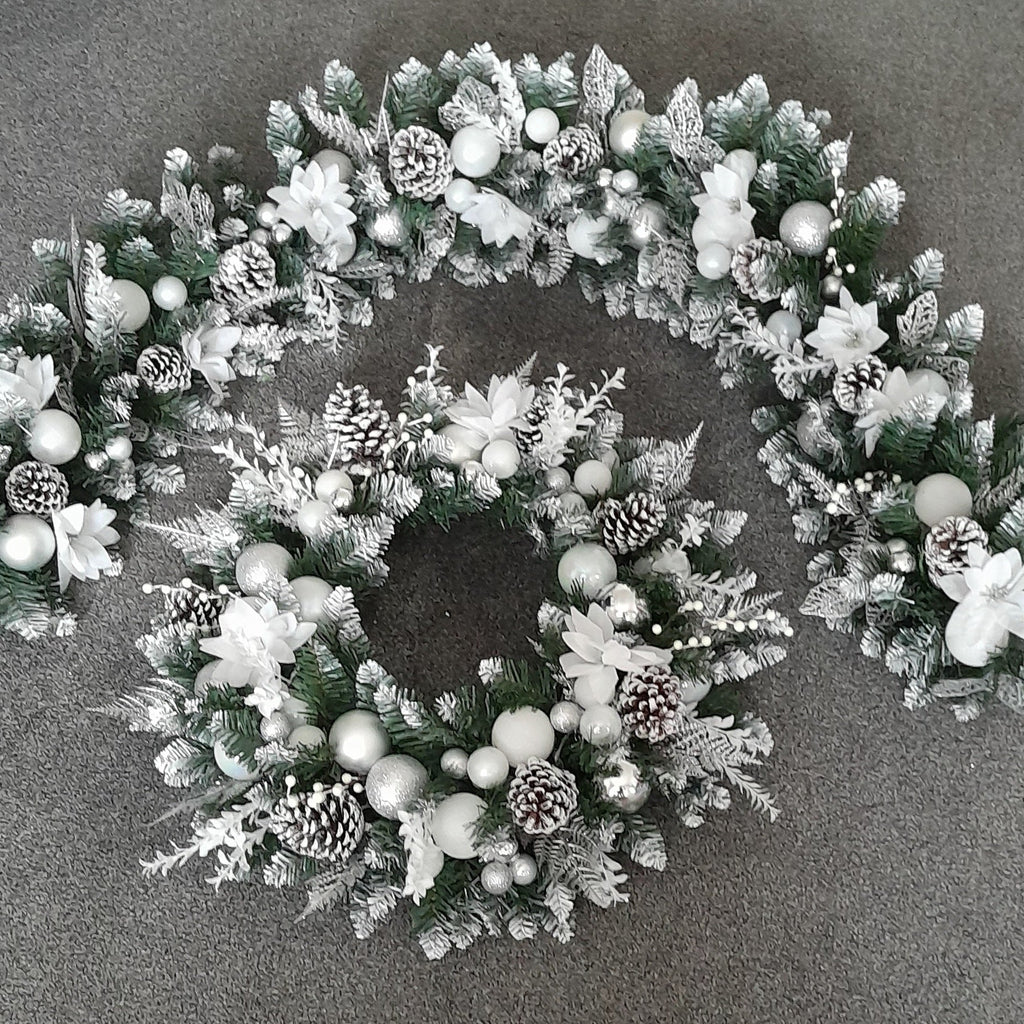 Matching silver and white Christmas 6-foot garland and 22-inch door wreath with white flowers, baubles and pine cones