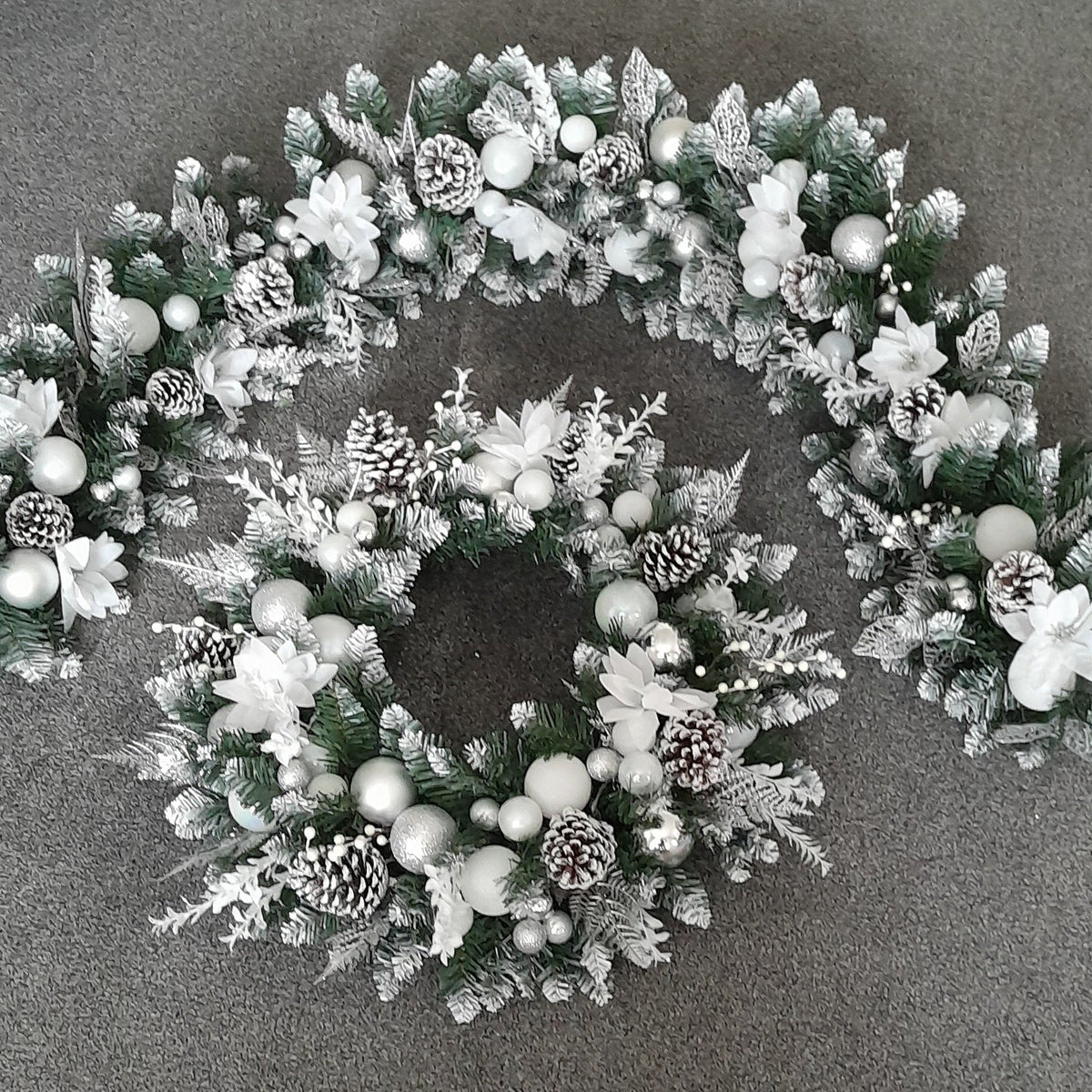 Matching silver and white Christmas 6-foot garland and 22-inch door wreath with white flowers, baubles and pine cones