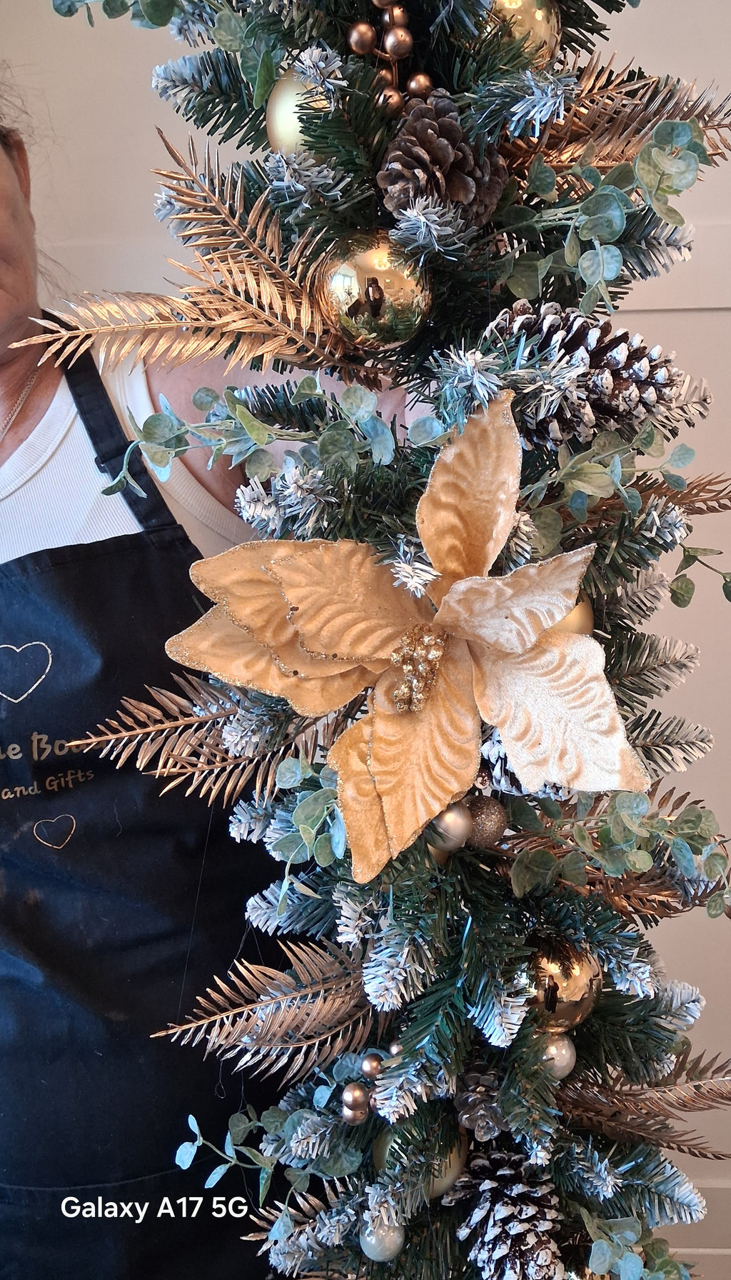Gold, champagne and white Christmas garland held upright to show its full length
