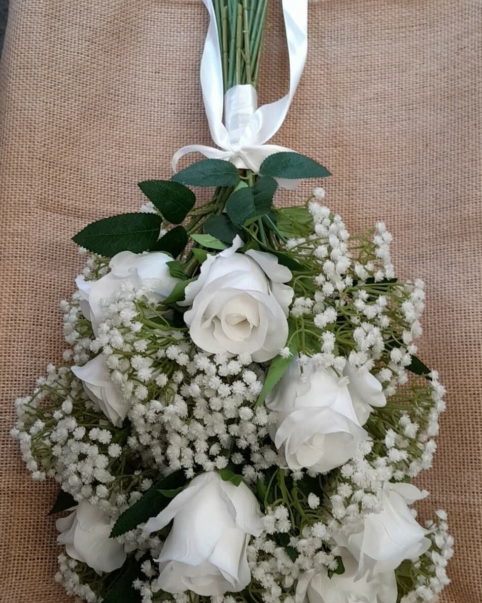 Ottilie bridal bouquet held - white roses and gypsophila with white ribbon