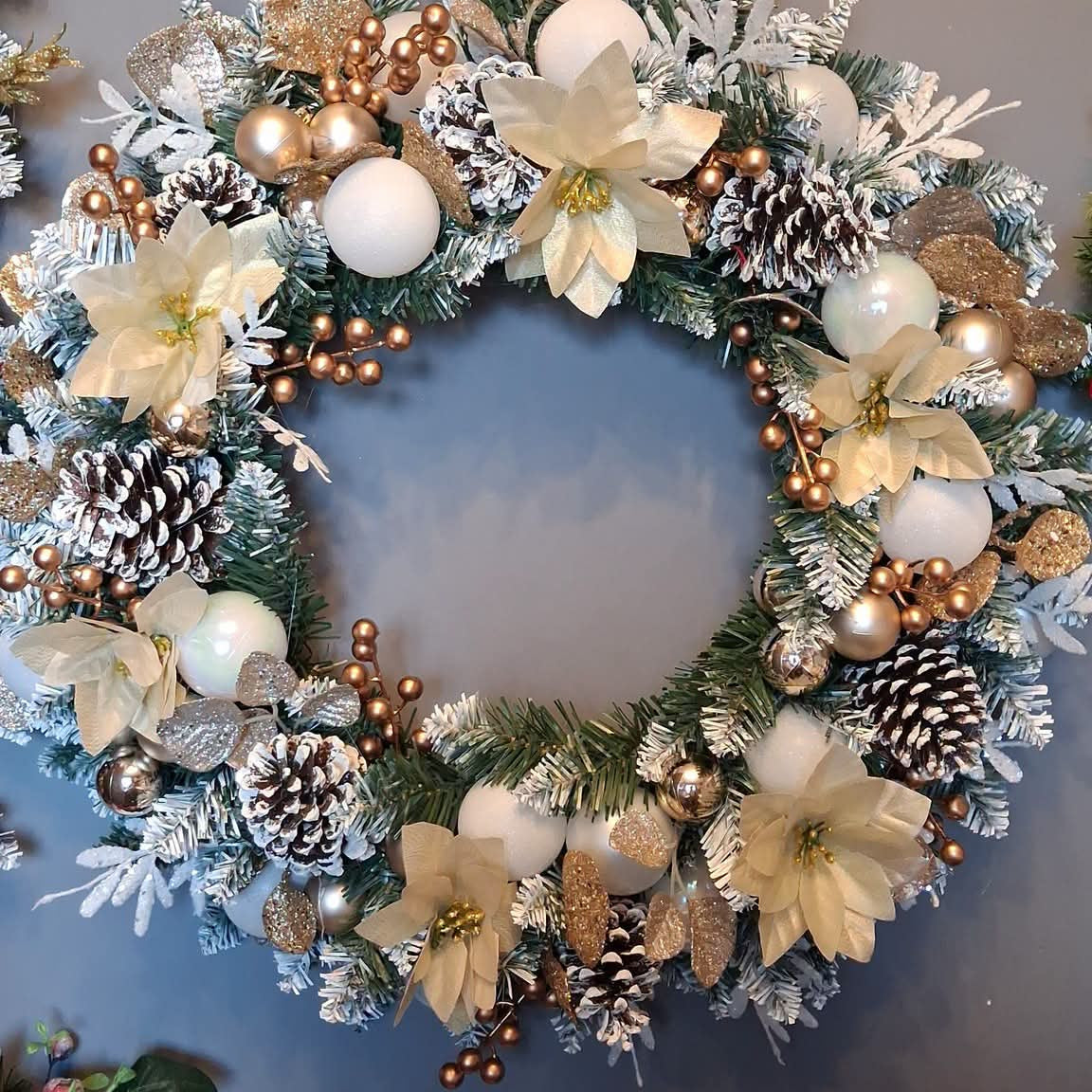 22-inch ivory and gold Christmas wreath with cream poinsettia-style flowers, white baubles, gold berries and snow-tipped pine cones