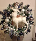 22-inch Christmas wreath with a white reindeer, navy and silver baubles, frosted-look greenery and snow-tipped pine cones