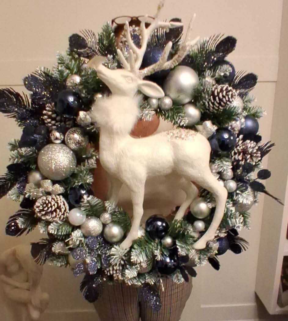 22-inch Christmas wreath with a white reindeer, navy and silver baubles, frosted-look greenery and snow-tipped pine cones