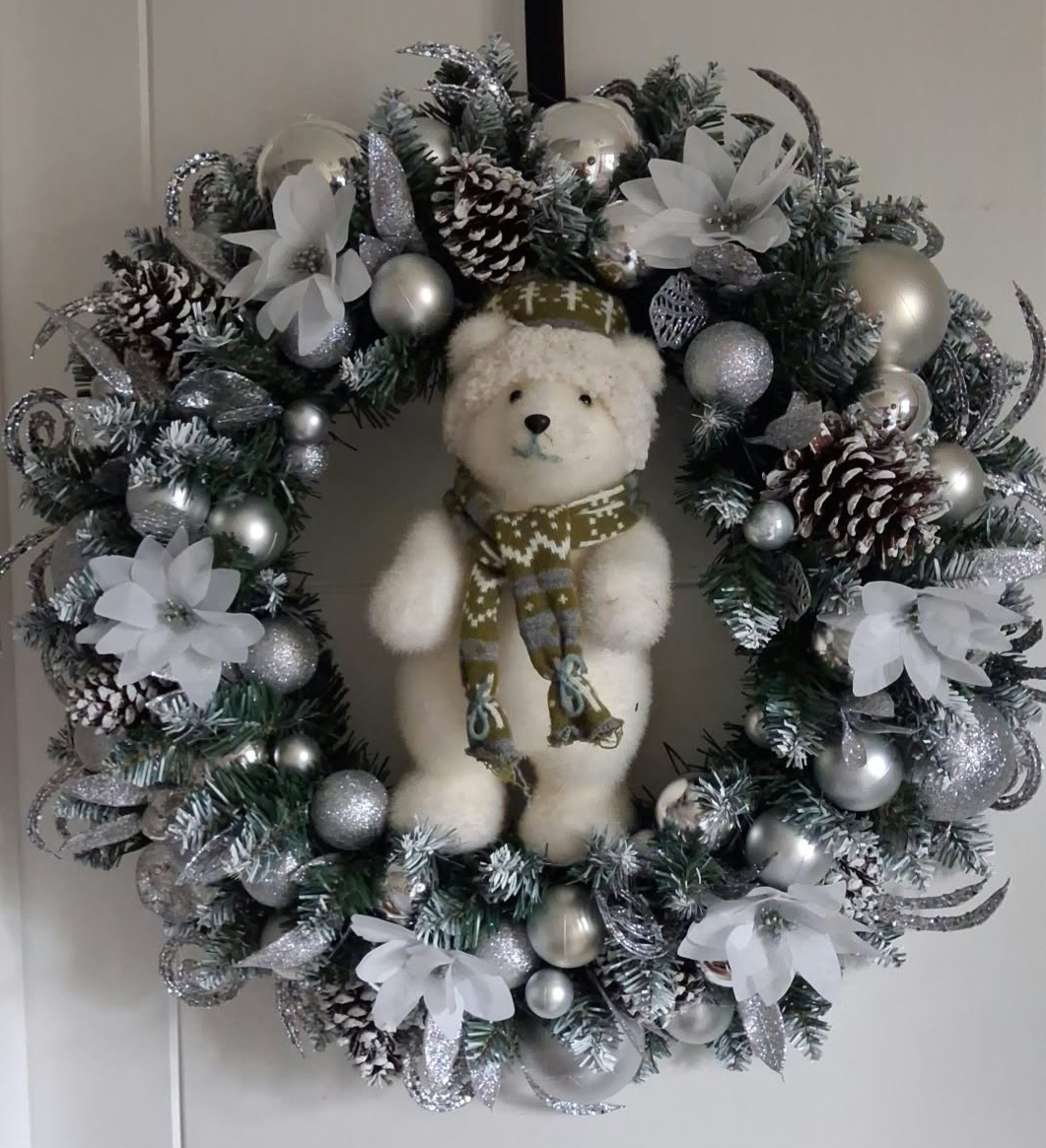 24-inch silver and white Christmas wreath with a polar bear centrepiece, silver baubles, white flowers and pine cones