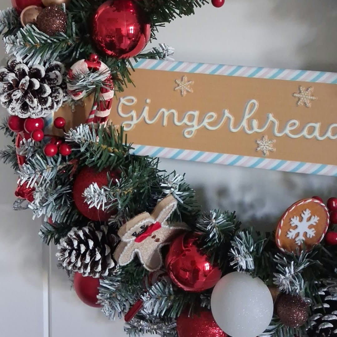 Close-up of gingerbread decorations, red baubles and frosted pine cones