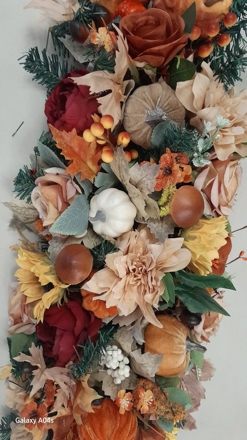 Autumn door frame garland detail with cream dahlias, white pumpkin, sunflowers and rich autumn foliage